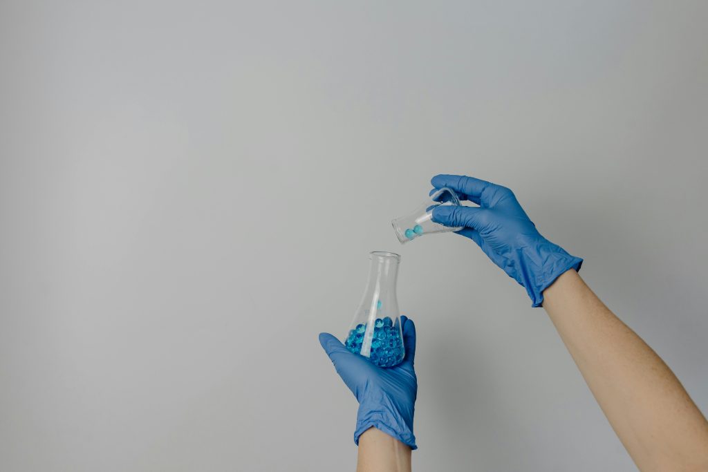 Person pouring pellets into beaker