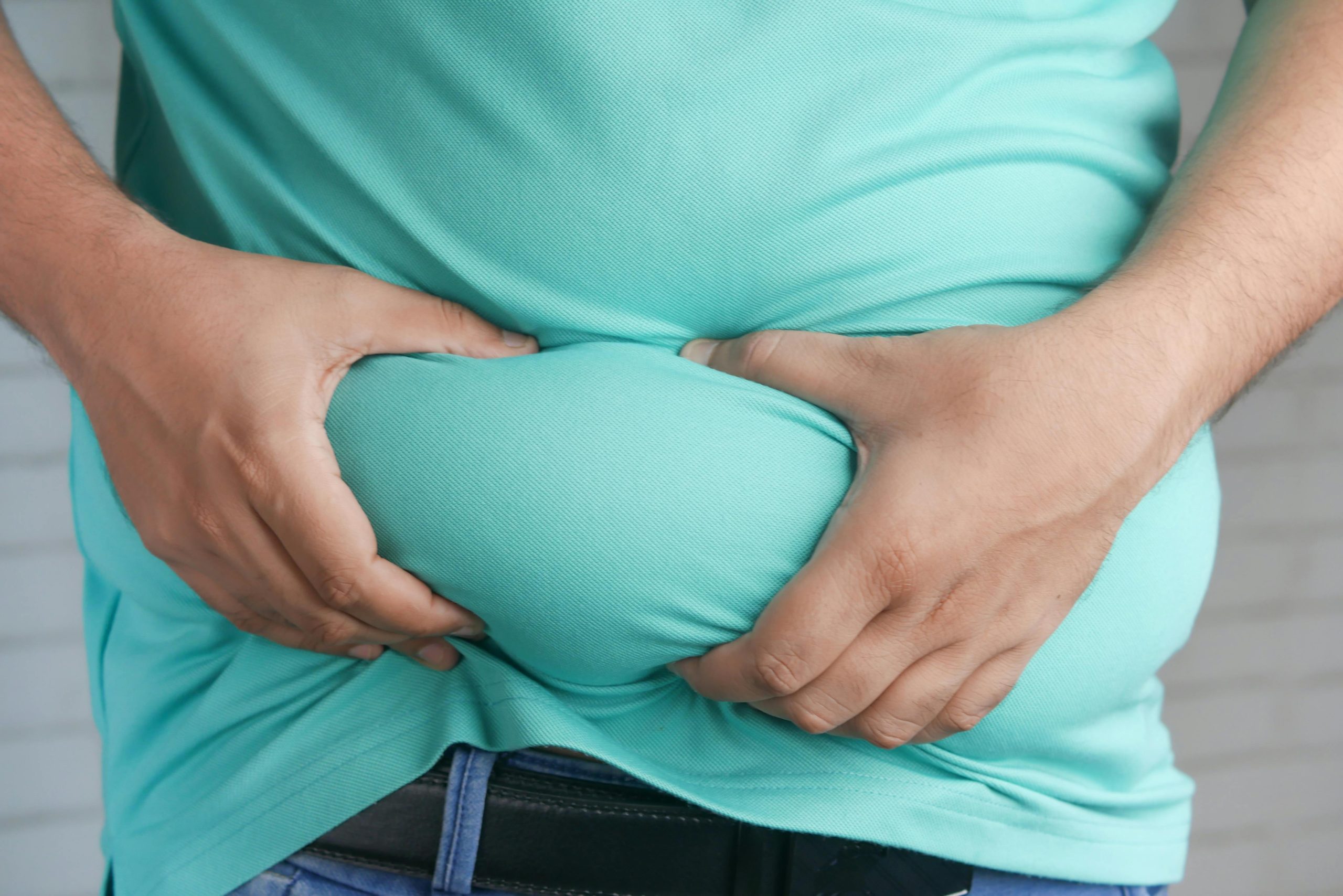 Overweight person holding belly