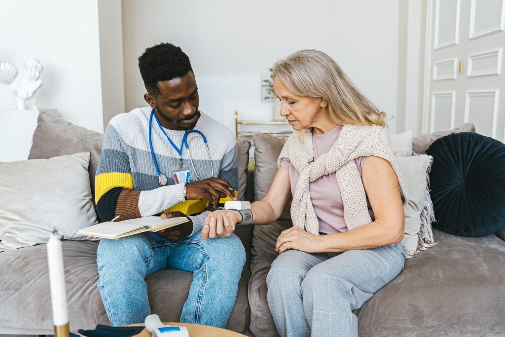 Woman having her blood pressure taken on a couch